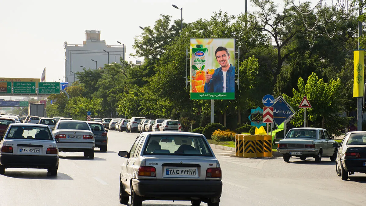 استرابورد عمودی کنار خیابانی درختی در مشهد، همتراز با خط دید رانندگان